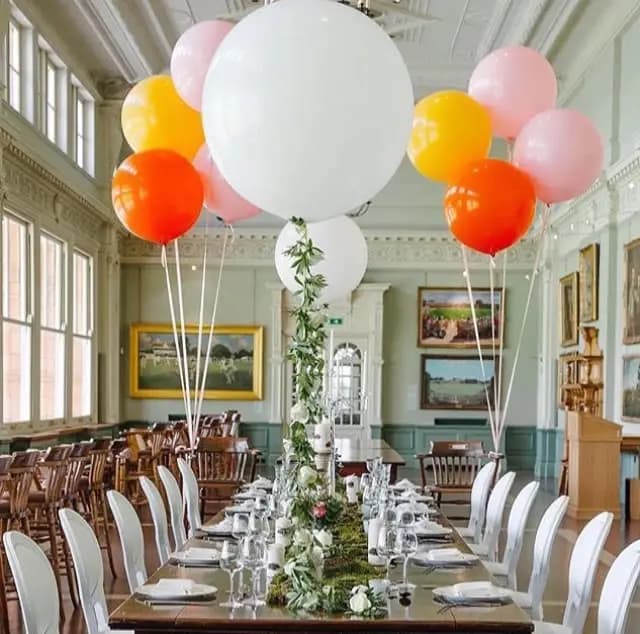 Long celebration table with a colourful balloon installation