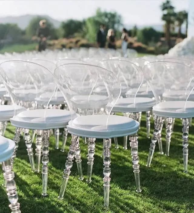 Clear chairs arranged for an outdoor ceremony