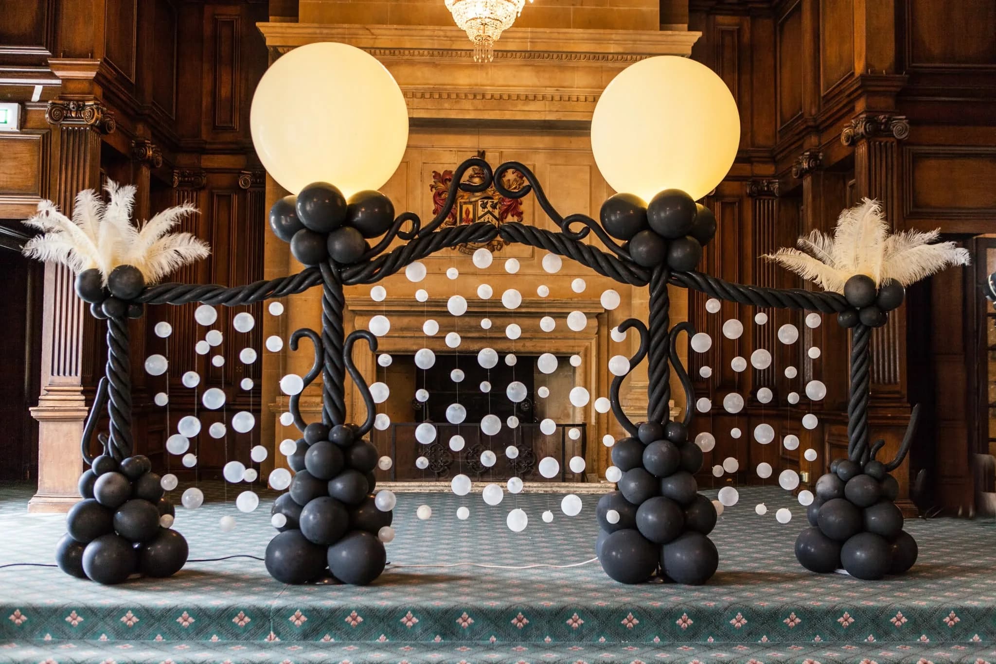 Black and gold balloon arch with ostrich feather detail