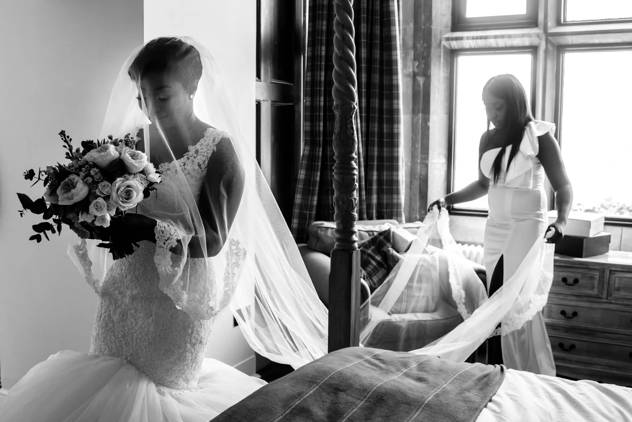 Bride with bouquet and veil in a four-poster bedroom