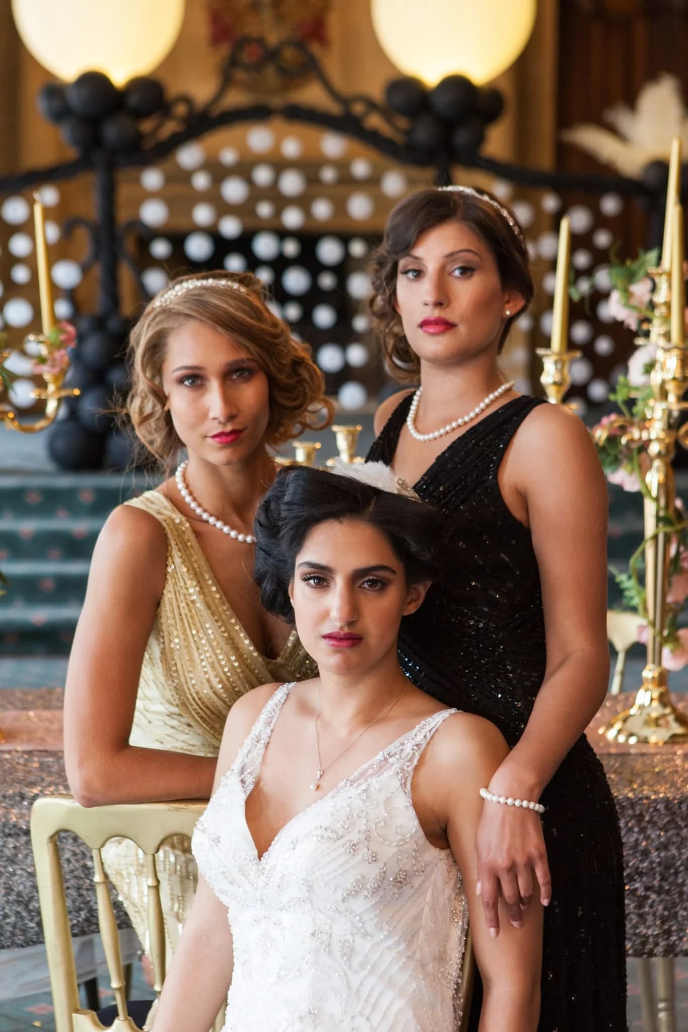 Three women in vintage-style dresses at a styled celebration