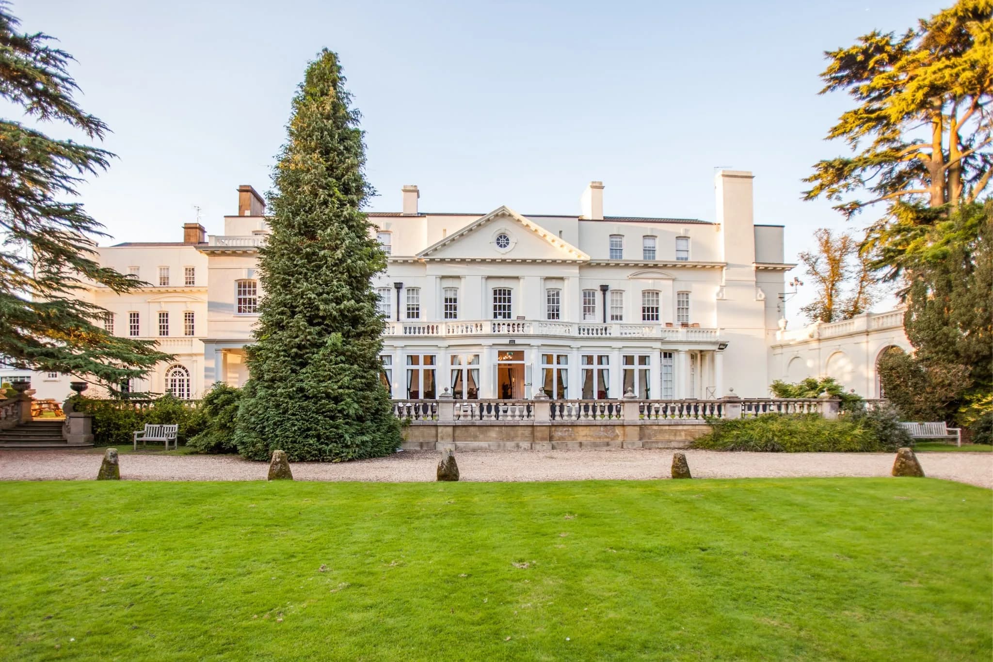 Manor house venue exterior with lawn and mature trees